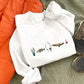 white crewneck with custom embroidered fishing icons including cattails, bass fish, fishing rod, canoe, and bobbin across the chest