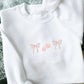 White sweatshirt with embroidered double loop mini bow and candy corn design 