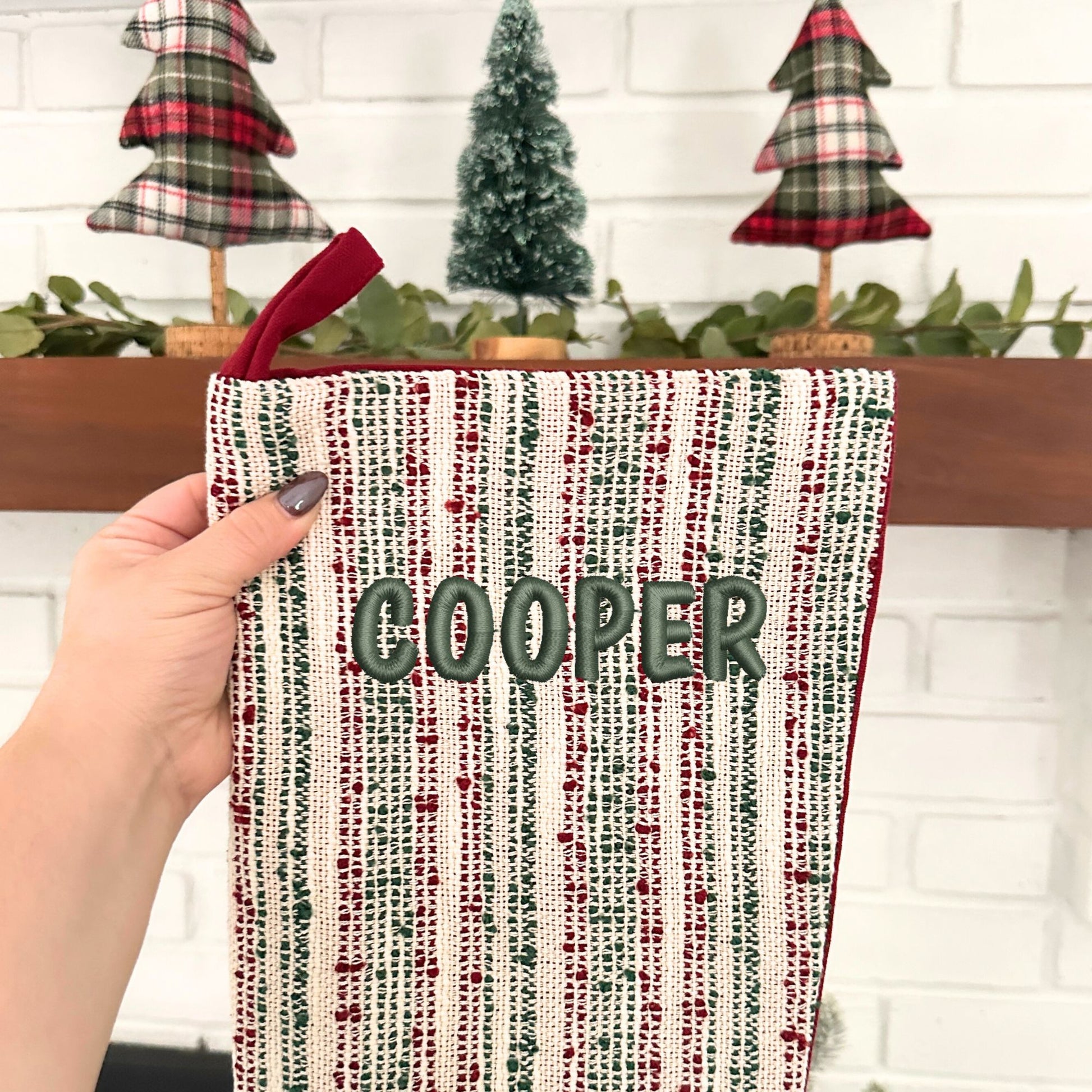 multi-striped textured red and green christmas stocking with custom name embroidery in toon font and ivy thread