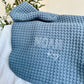 pacific blue waffle knit baby blanket with  embroidery in white thread in a mixed block and script font