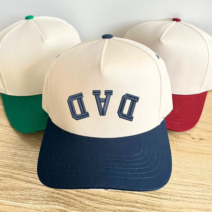 navy two-tone canvas trucker hat with custom upside down curved athletic font DAD embroidered design in navy thread.