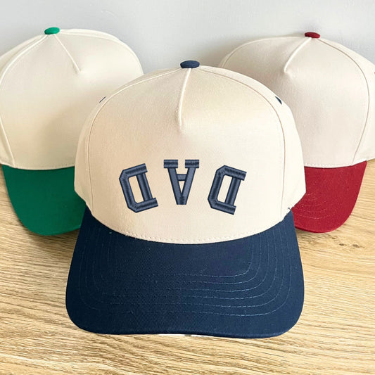 navy two-tone canvas trucker hat with custom upside down curved athletic font DAD embroidered design in navy thread.