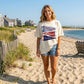 Woman wearing a t-shirt with coastal flags design on a beach