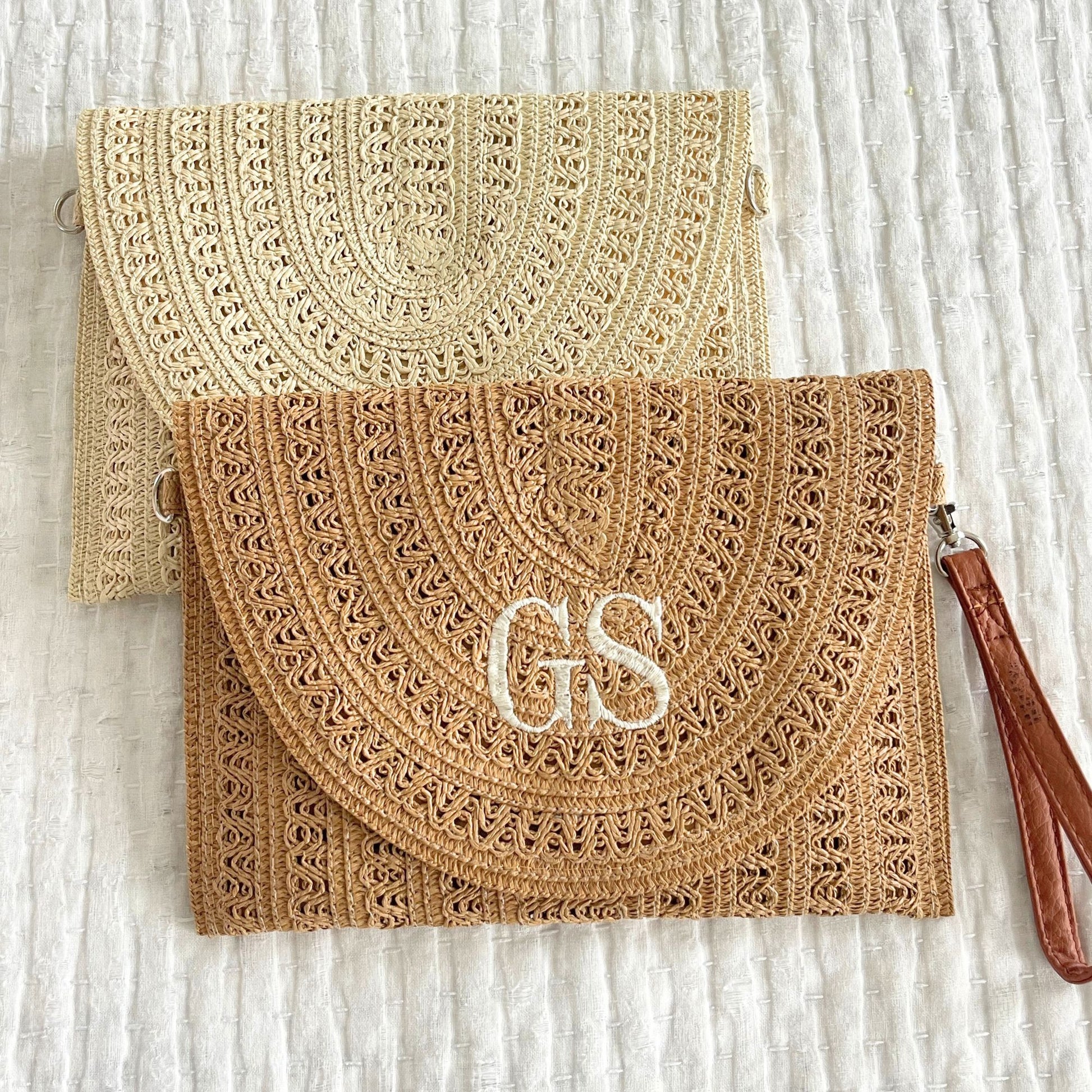  a woven taupe straw fold-over clutch purse featuring a two letter embroidered monogram in natural  thread and a blank beige fold-over woven clutch