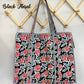 Floral patterned bag hanging on a wooden rack with 'Black Floral' text.
