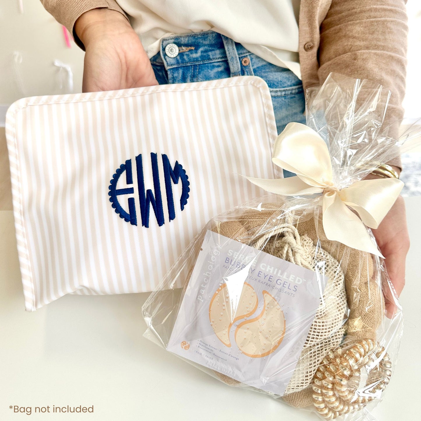 custom embroidered makeup pouch with custom spa bundle in a clear pouch  tied with a beige bow