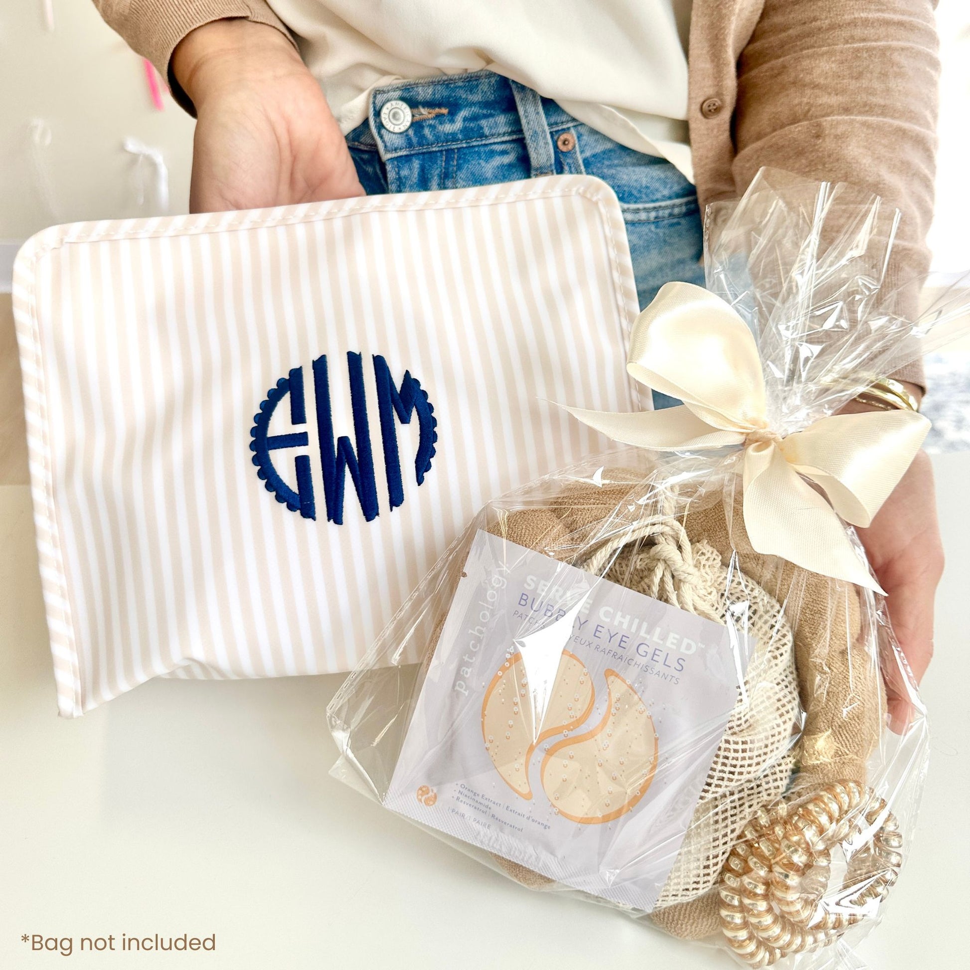 custom embroidered makeup pouch with custom spa bundle in a clear pouch  tied with a beige bow
