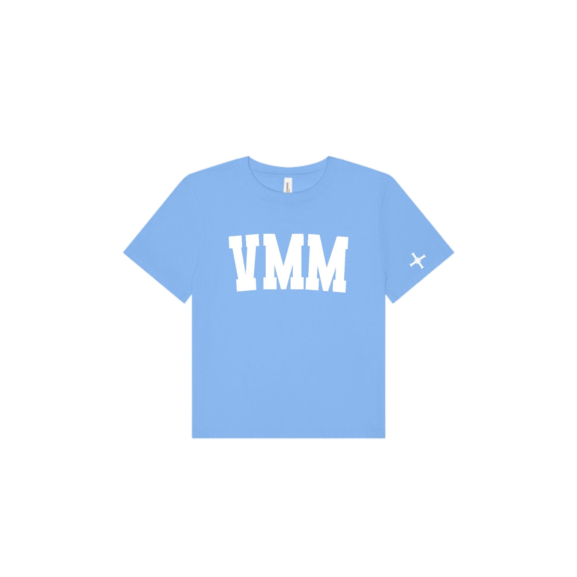 A light blue short-sleeve t-shirt with 'VMM' printed in bold white block letters across the chest and a small white 'cross' logo on the left sleeve, shown on a plain white background.