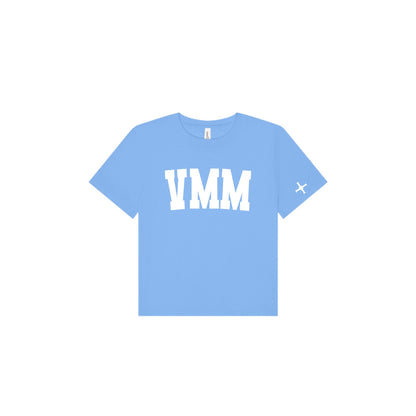 A light blue short-sleeve t-shirt with 'VMM' printed in bold white block letters across the chest and a small white 'cross' logo on the left sleeve, shown on a plain white background.