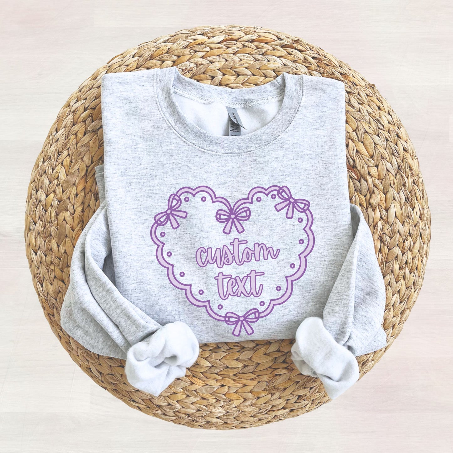Ash grey sweatshirt with a printed purple doily heart design featuring a place for 'custom text' in the center of the heart