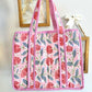 Floral patterned tote bag with pink and white stripes on a light background