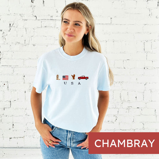 woman wearing a chambray comfort colors t-shirt with cute embroidered usa icons and usa design
