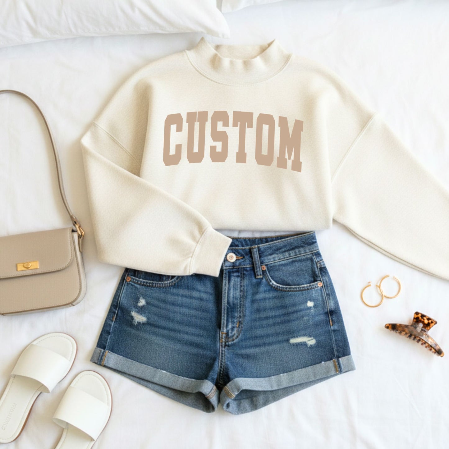 Custom sweatshirt with denim shorts and accessories on a white surface