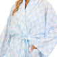 Woman wearing a light blue and white patterned robe on a white background