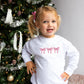 toddler girl wearing a white crewneck sweatshirt with 3 embroidered bows across the chest in pink thread.