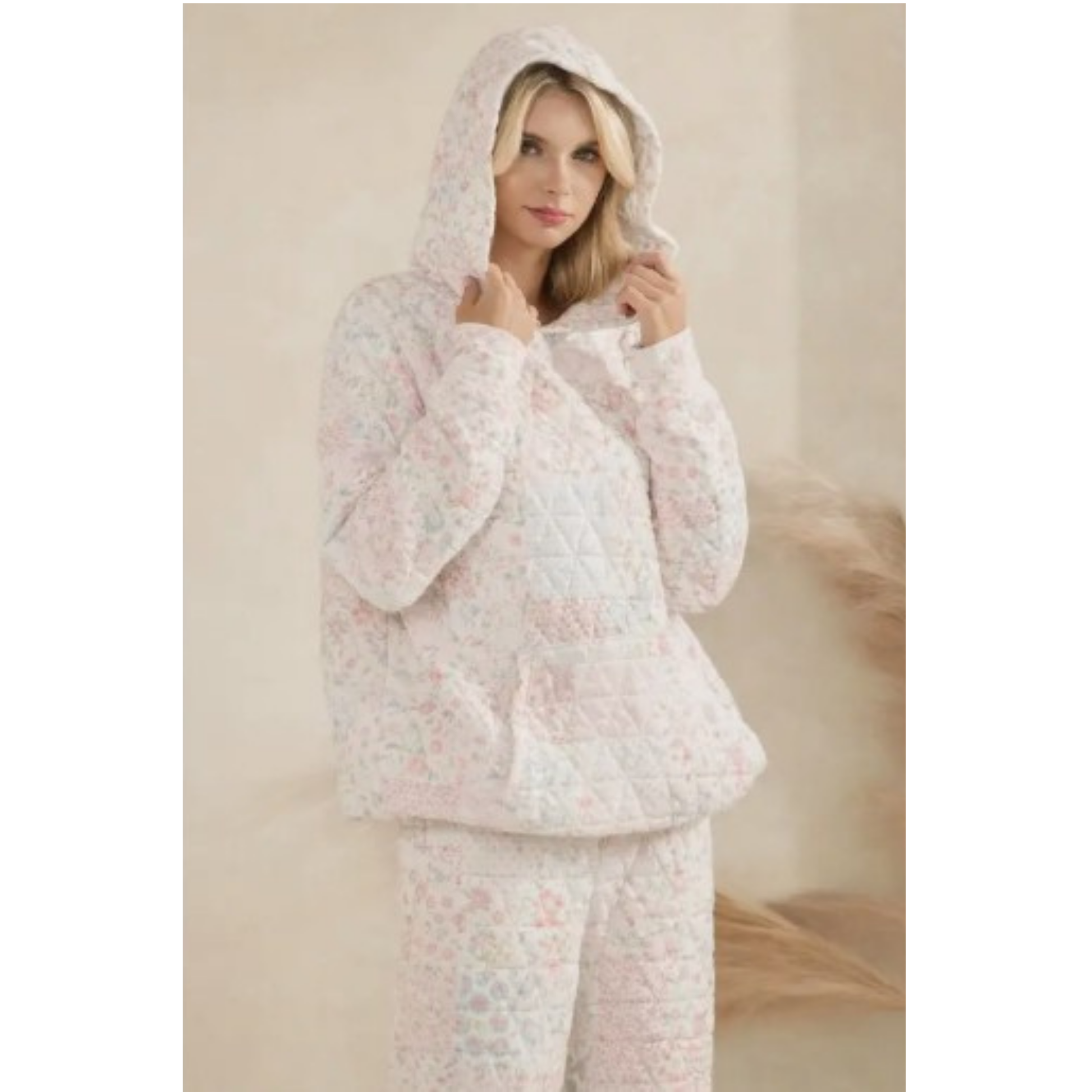 Woman wearing a floral quilted hoodie against a neutral background