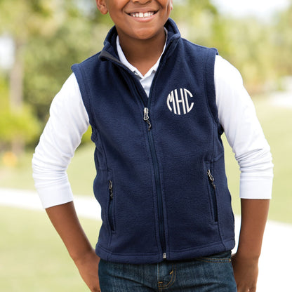 young boy wearing a navy vest with embroidered monogram on the left chest