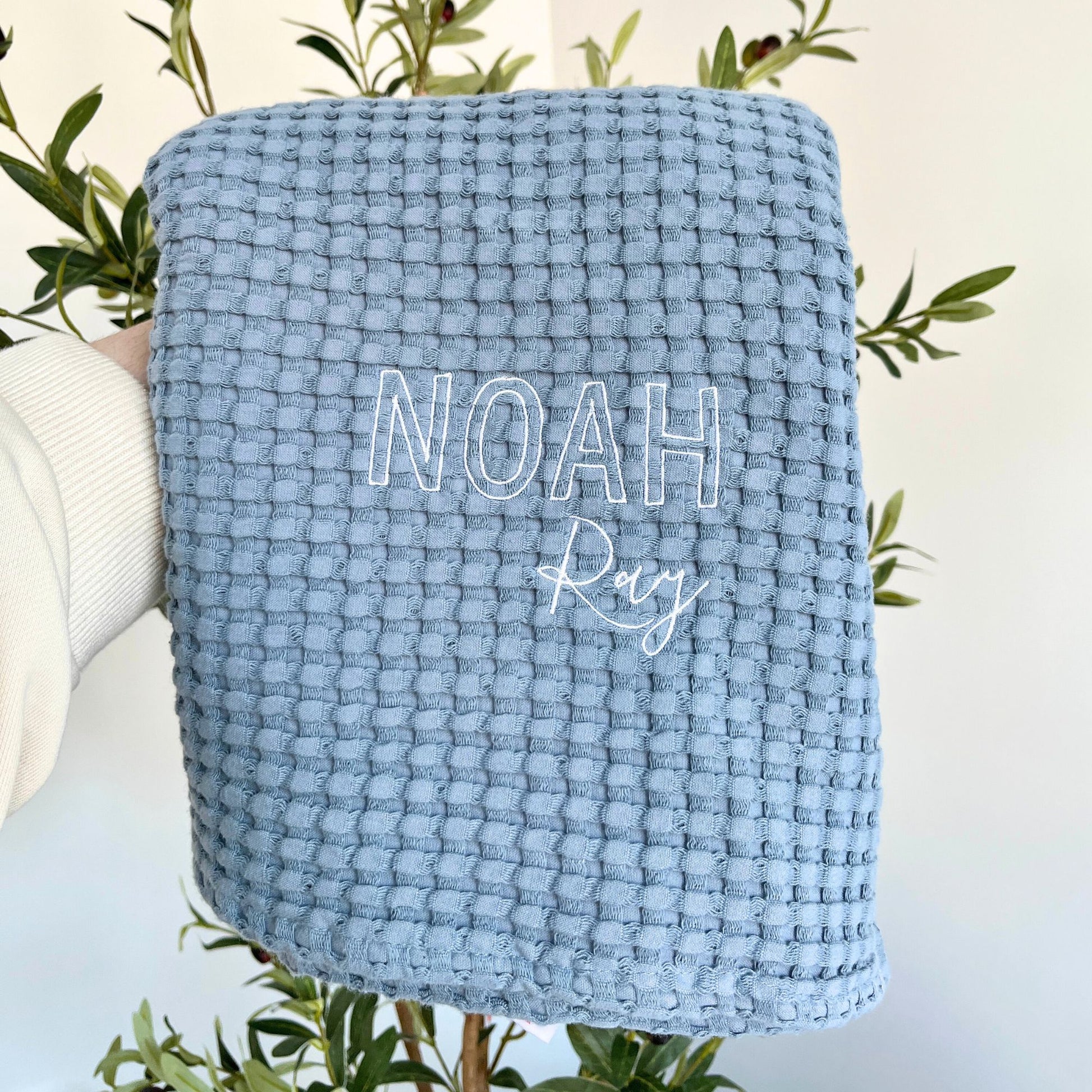 pacific blue waffle knit baby blanket with  embroidery in white thread in a mixed block and script font