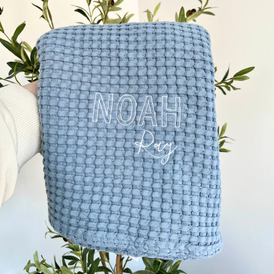 pacific blue waffle knit baby blanket with  embroidery in white thread in a mixed block and script font