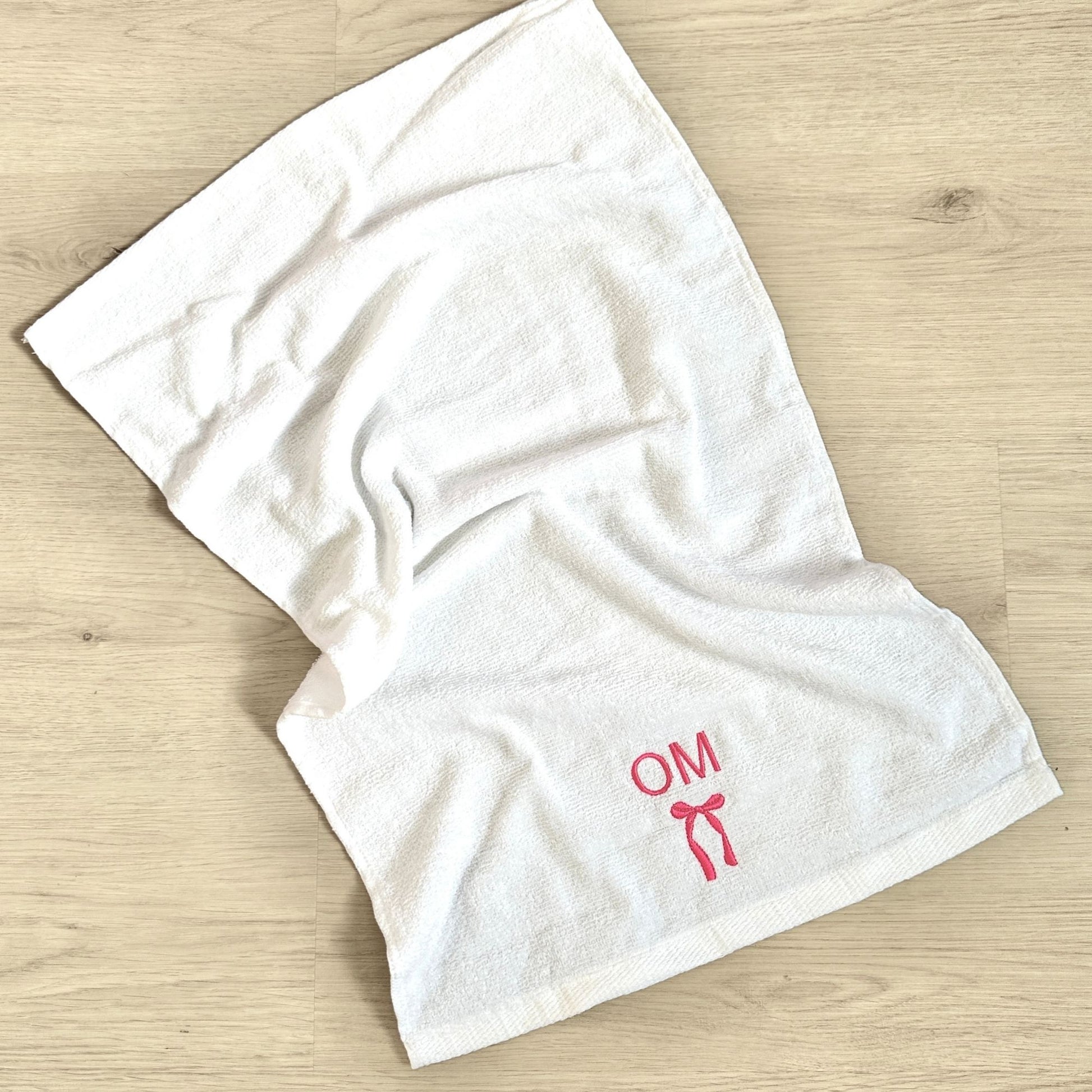 white gym hand towel with custom two letter and bow embroidered design in pink thread