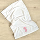 white gym hand towel with custom two letter and bow embroidered design in pink thread