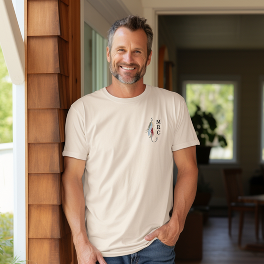 man wearing an ivory comfort colors tee with an embroidered fly fishing lure monogram with three custom letters on the right side of the lure 