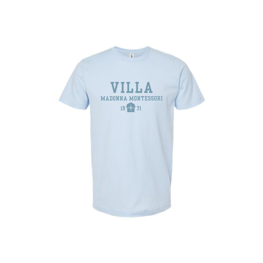 A light blue short-sleeve crewneck t-shirt with a dark blue graphic print on the chest reading 'VILLA MADONNA MONTESSORI 1971'.