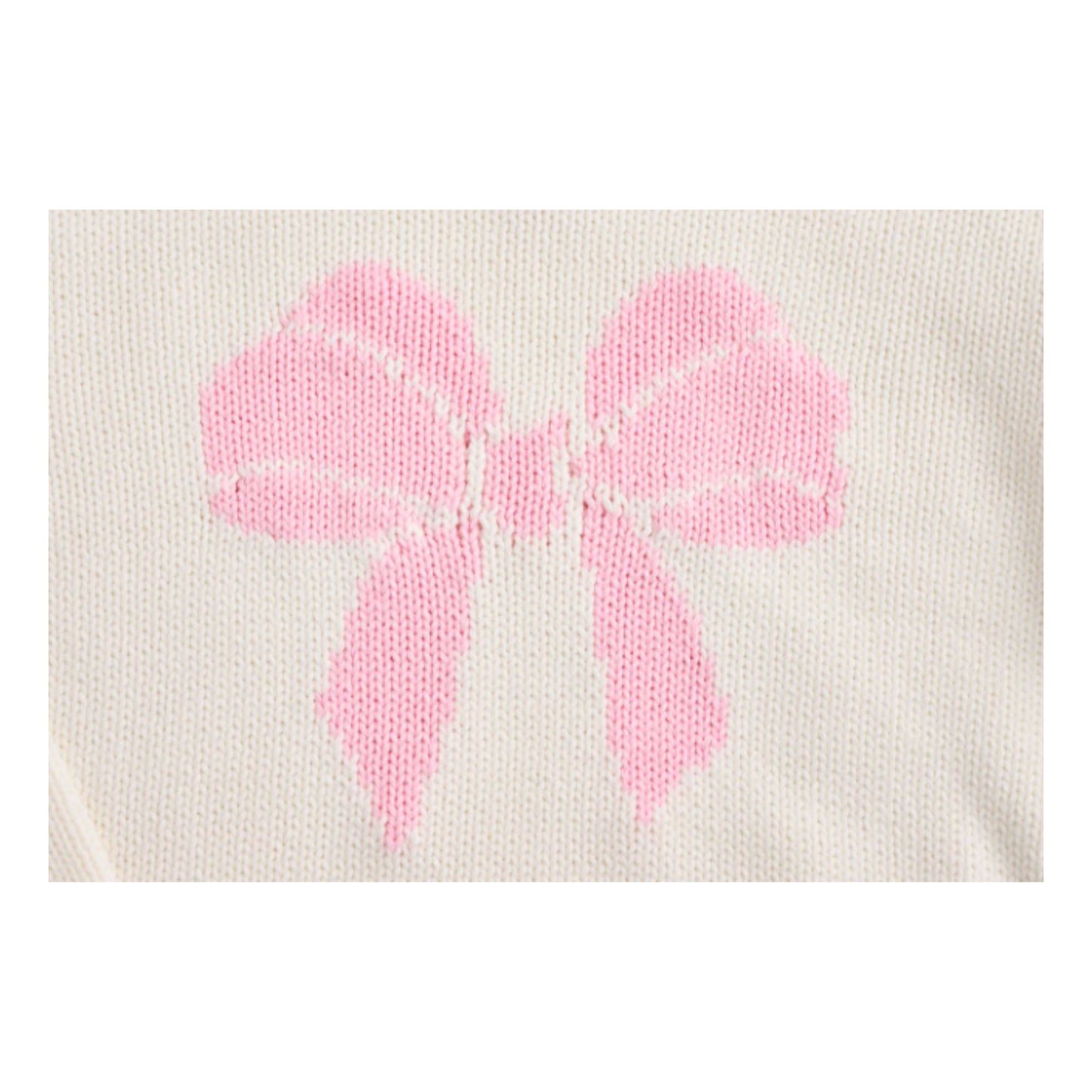 close up detail of pink bow stitched on a white sweater