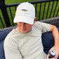 Man wearing a stone legacy baseball hat with embroidered mini rainbow trout design