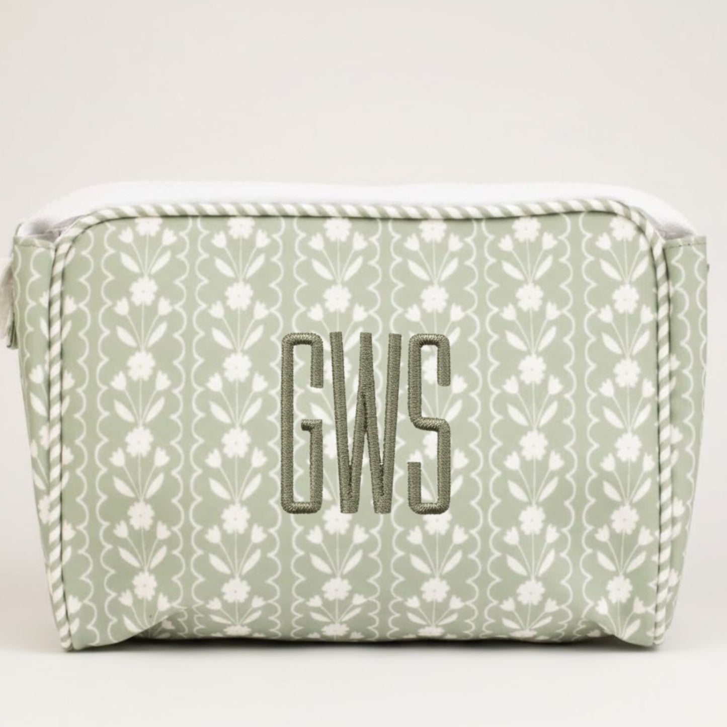 Green floral-patterned pouch with 'GWS' monogram on a white background