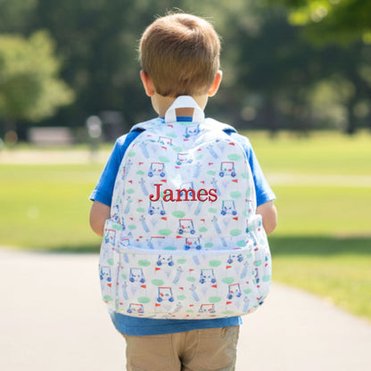 Child wearing a golf patterned backpack with 'James' on it in a park setting