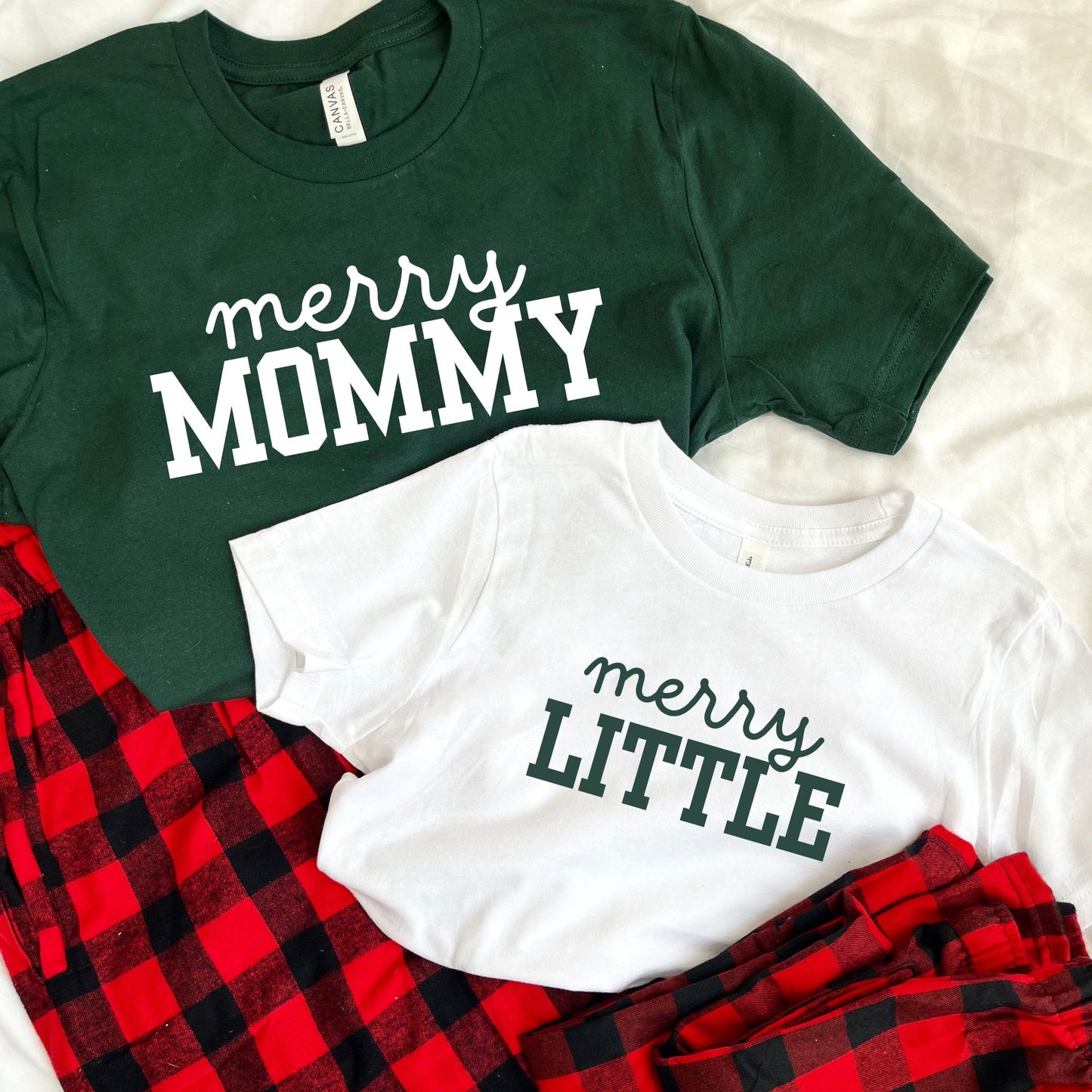 matching family Christmas  pajama sets. Adult Forest green tee with merry mommy printed in white ink and youth white tee with merry little printed in green ink.