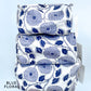 Stack of blue floral-patterned fabric pouches on a light blue background