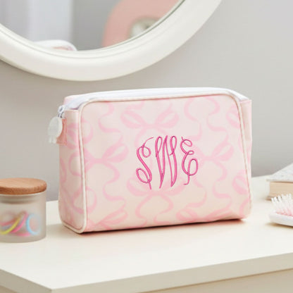 Pink bow toiletry bag with monogram on a vanity table