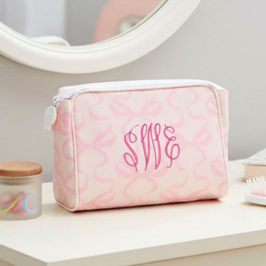 Pink bow toiletry bag with monogram on a vanity table