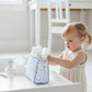 Child interacting with a diaper bag on a white surface
