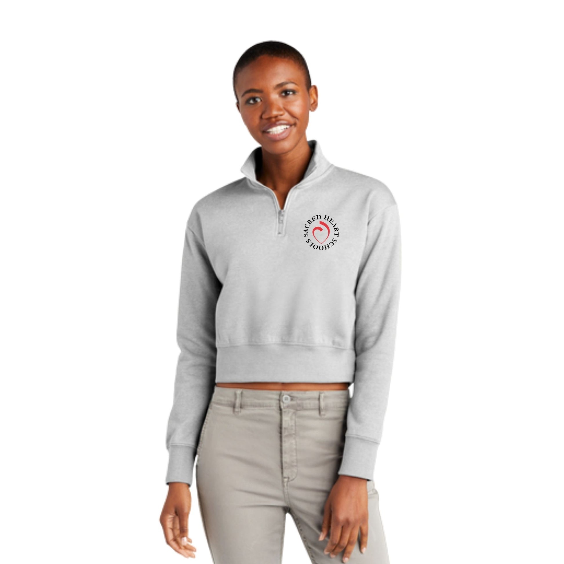 woman wearing an athletic heather cropped quarter zip with custom printed sacred heart schools heart logo on the left chest in black and red ink