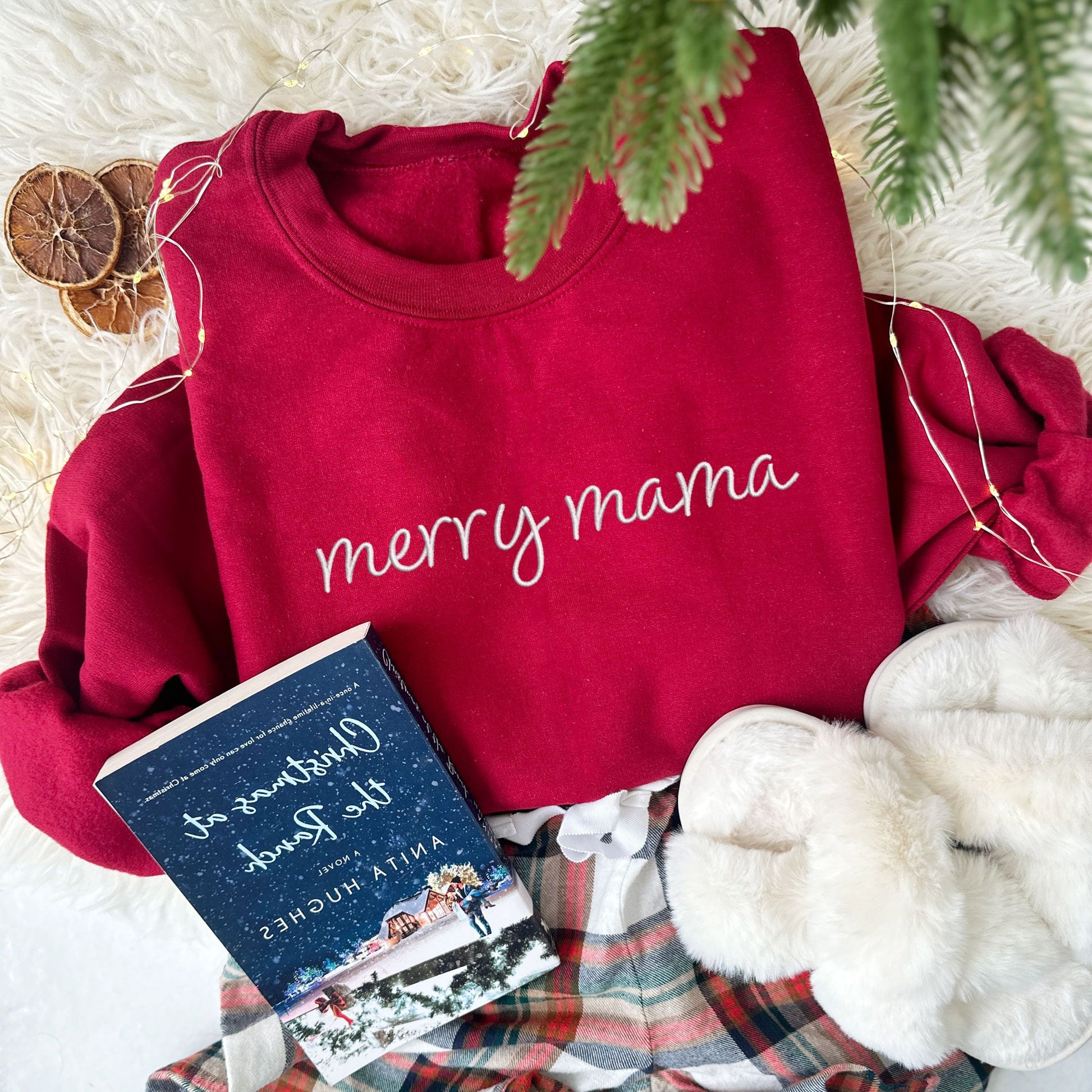 cardinal red crewneck sweatshirt with embroidered merry mama in white thread styled with Christmas decor, pajama shorts  and slippers