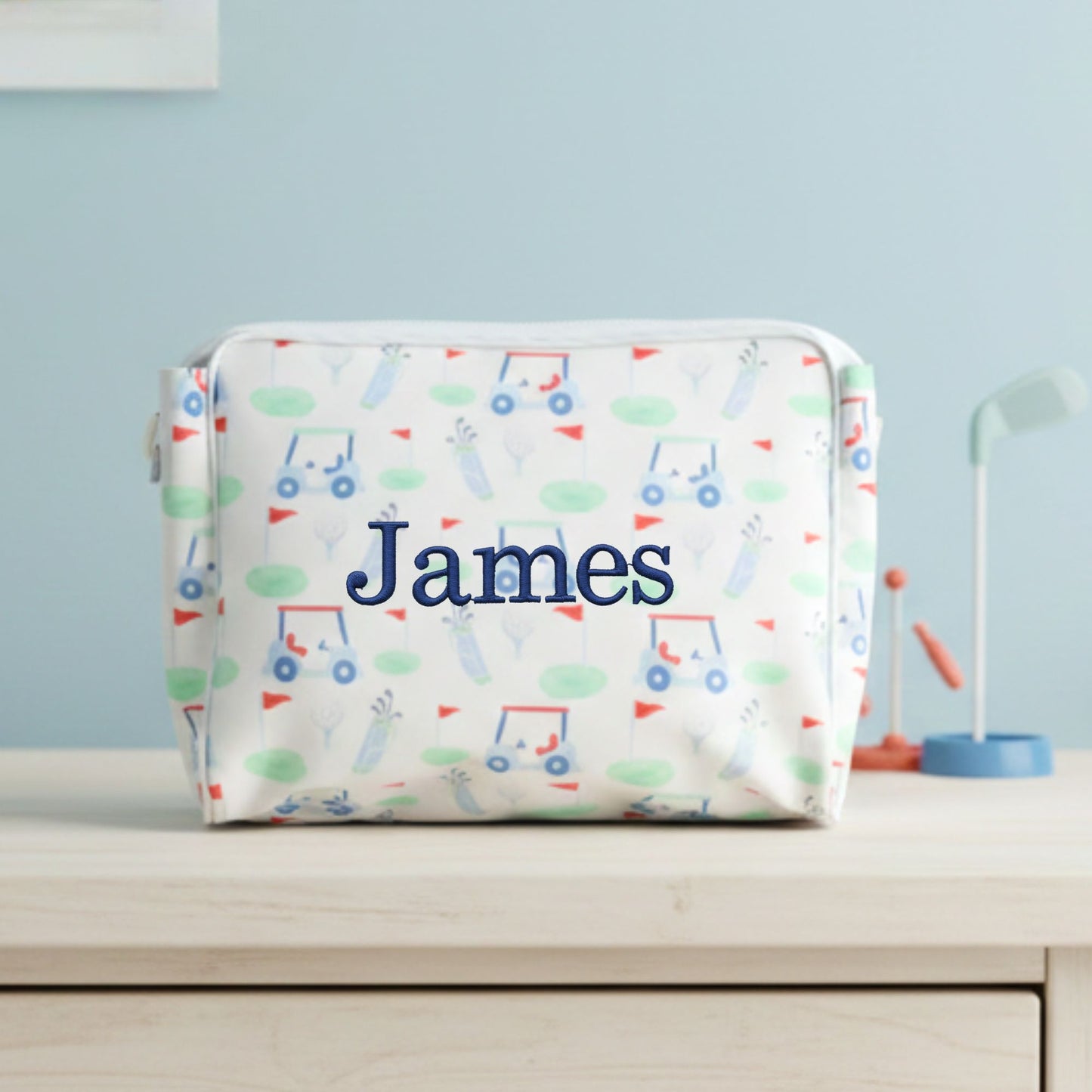 Personalized golf patterned pouch with 'James' embroidered on the front on a light blue background