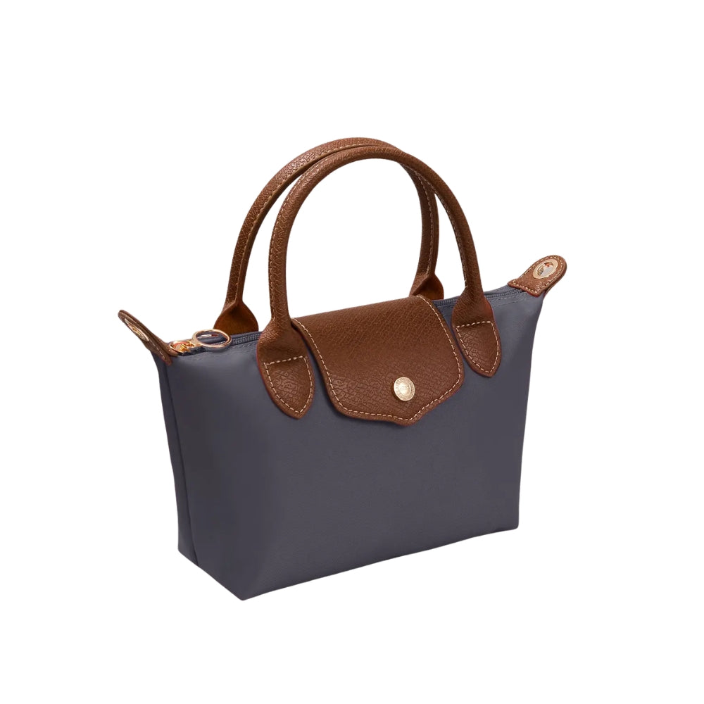 A small structured handbag in dark gray with brown leather handles, trim, and front flap, plus a gold-tone snap button, shown on a plain white background.