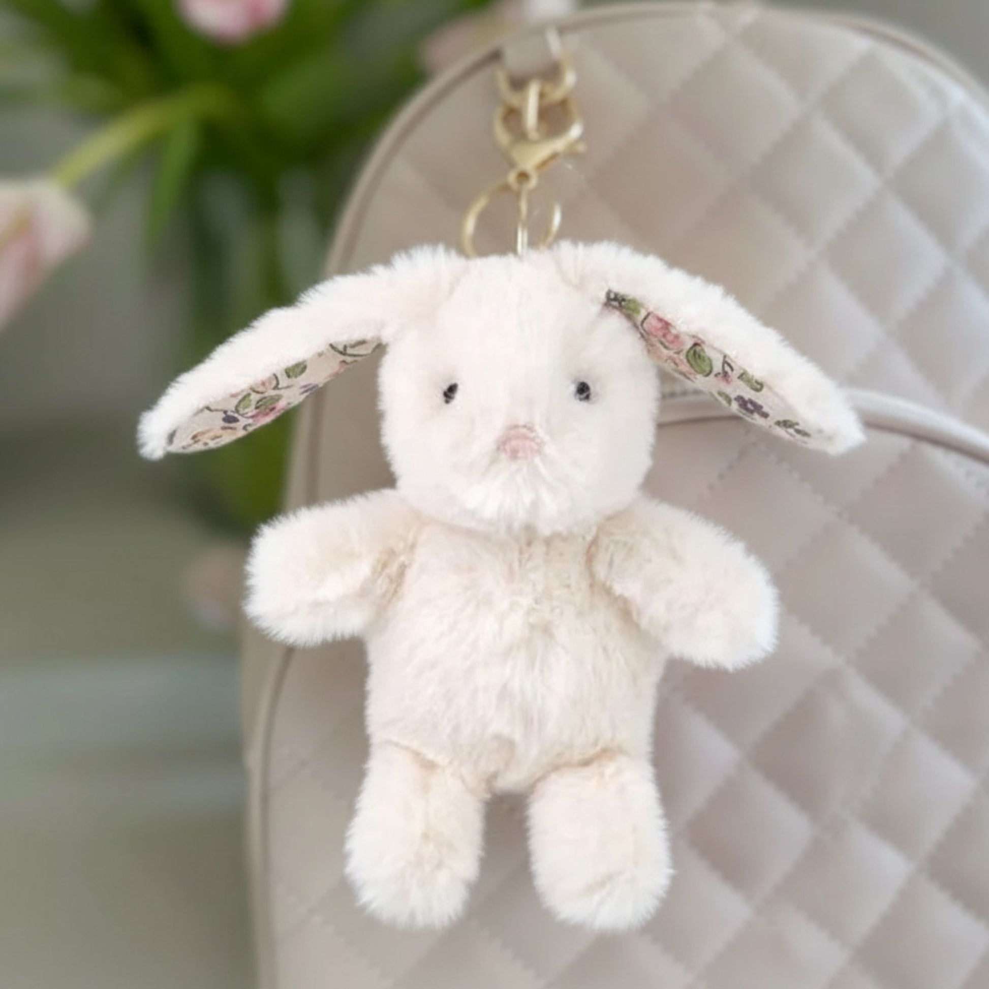 cream bunny bag charm hanging on a backpack
