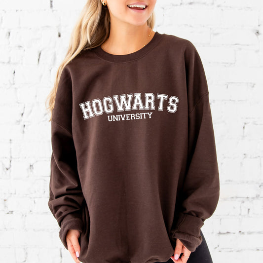 girl wearing an oversized dark chocolate crewneck sweatshirt with a custom hogwarts university dtf print in white