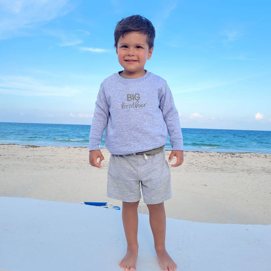 Little boy wearing heather crewneck with custom BIG brother embroidered design in gray thread