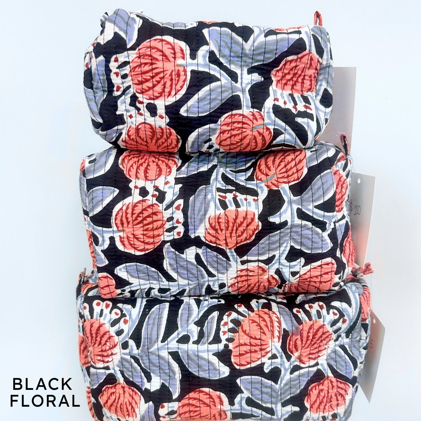 Stack of black floral patterned bags on a white background