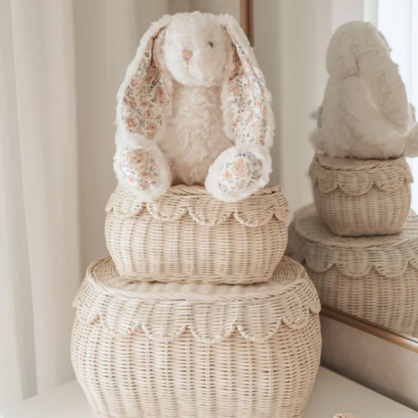 Decorative wicker basket with a floral-patterned bunny on top, against a neutral background.