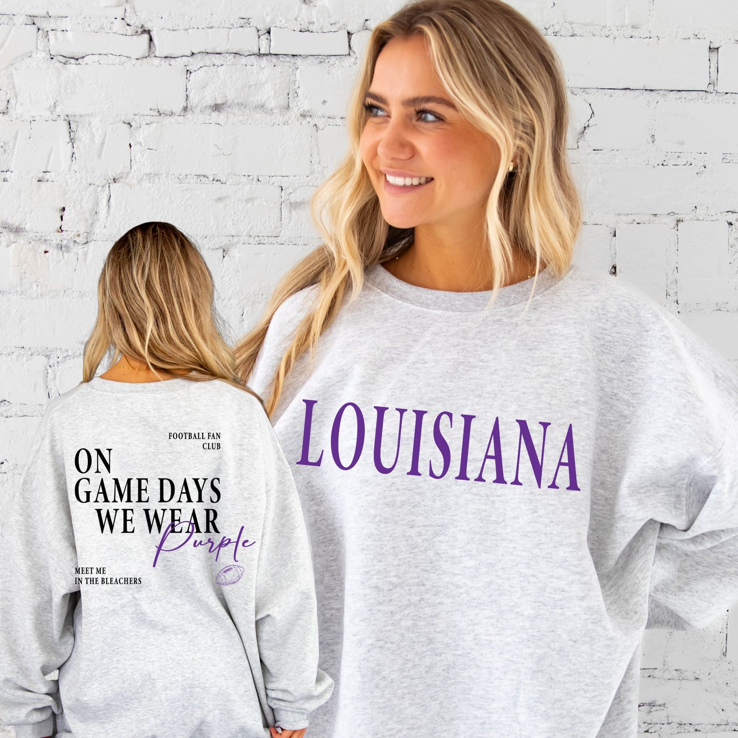 Two people wearing gray sweatshirts with 'LOUISIANA' and 'On Game Days We Wear Purple' text against a white brick wall.