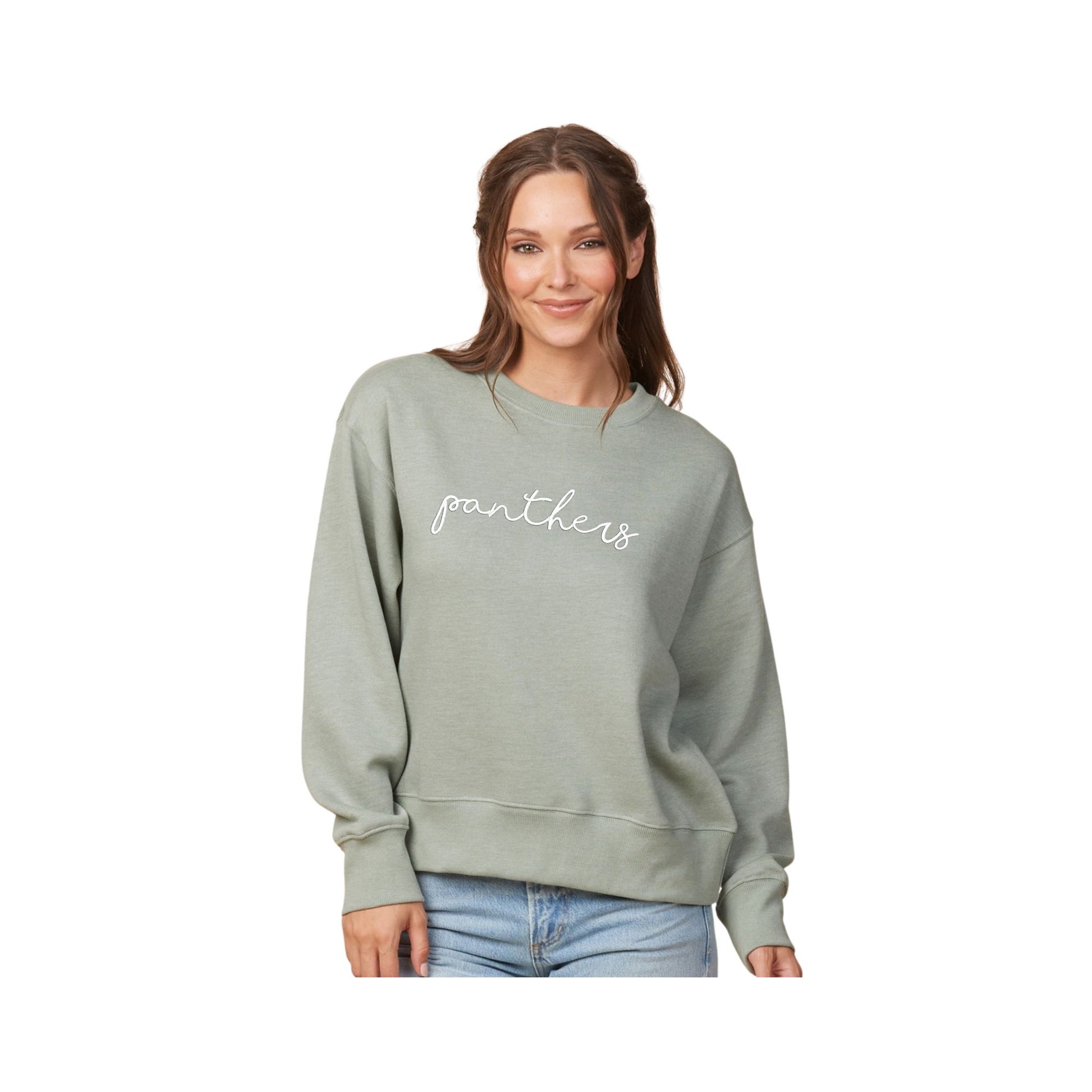 woman wearing a ladies boxy greenstone crewneck with embroidered panthers design in script font on the front center chest with white thread