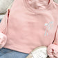 blush pink crewneck sweatshirt with custom ribbon bow and stacked initials embroidered on the left chest with white thread