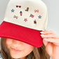 Person wearing a cap with various micro usa embroidered icons including a flag, star, and eagle.