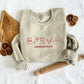 sand crewneck sweatshirt with embroidered outlined baking icons and custom text text on the center chest in red thread